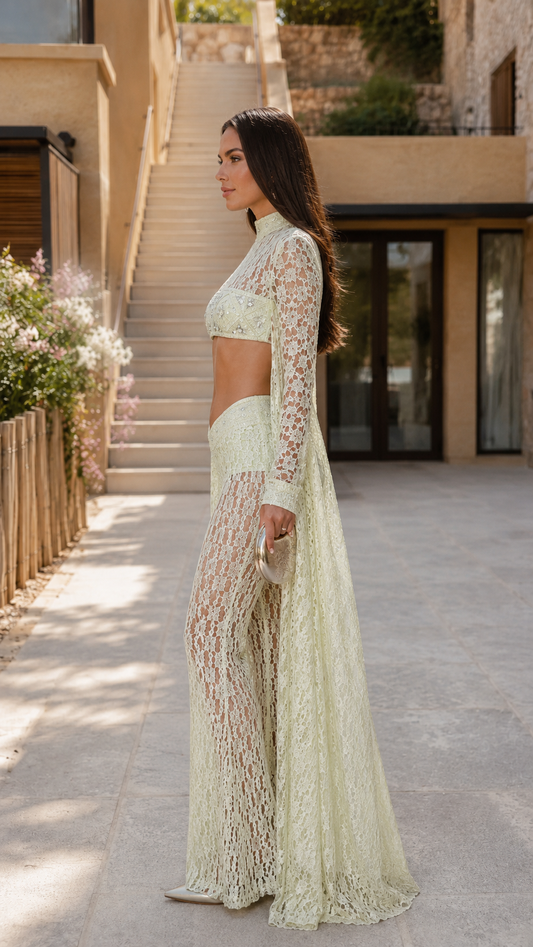 Side view of pale yellow lace cutout pants set with long sleeves and floor-length draped panels