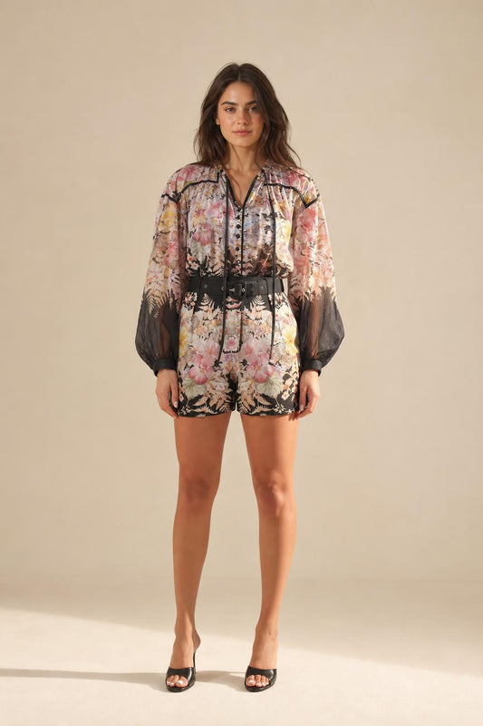 Front view of model wearing floral print long sleeve romper with black belt