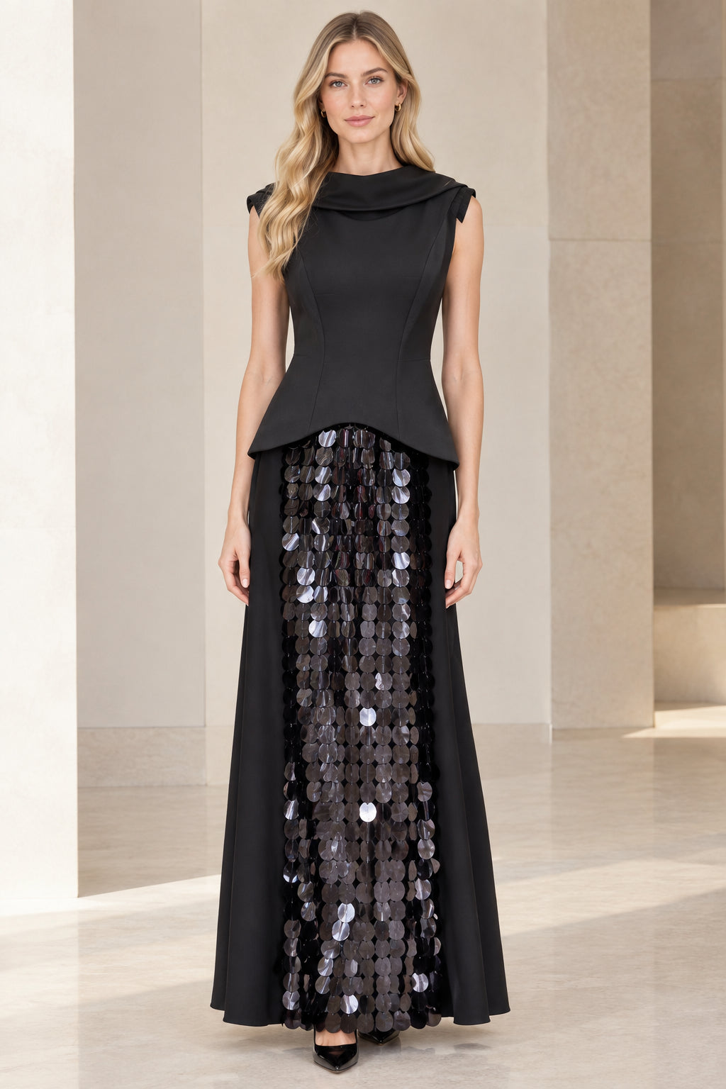 Front full-length view of model wearing black sleeveless cowl neck peplum maxi dress with sequin inset