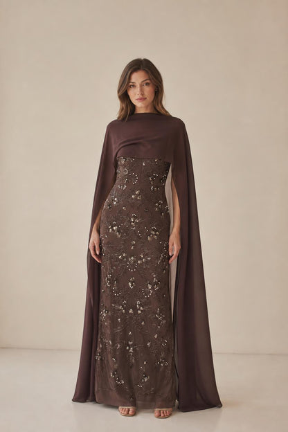 Front view of model wearing brown beaded maxi dress with cape