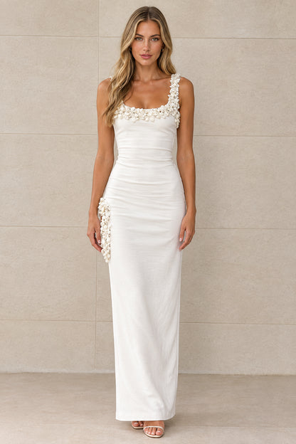 Front view of model wearing white sleeveless maxi dress with 3D floral neckline and hip accents