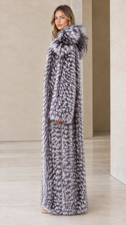 Side profile view of woman wearing long silver grey hooded faux fur coat