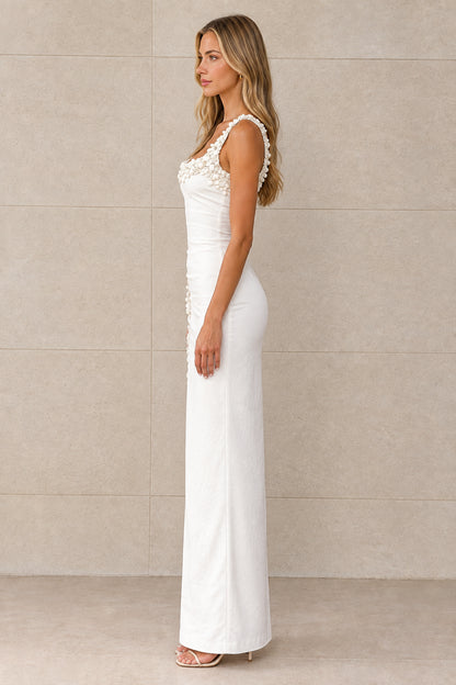 Side profile view of white floral applique column maxi dress