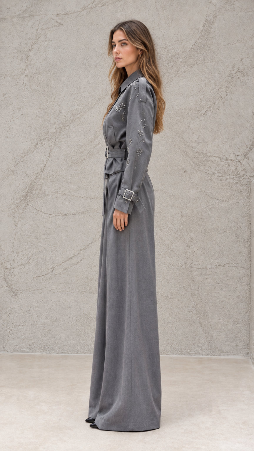 Side profile view of grey long sleeve wide-leg jumpsuit with buckled belt