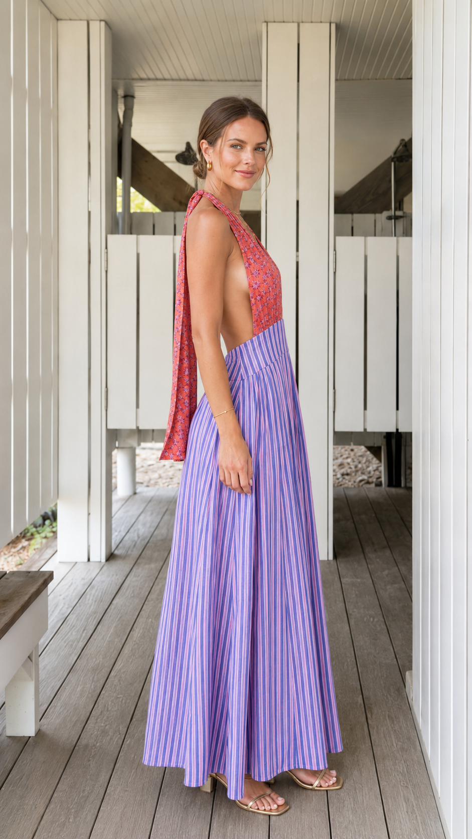 Side view of coral and lavender pleated halter maxi dress with open back