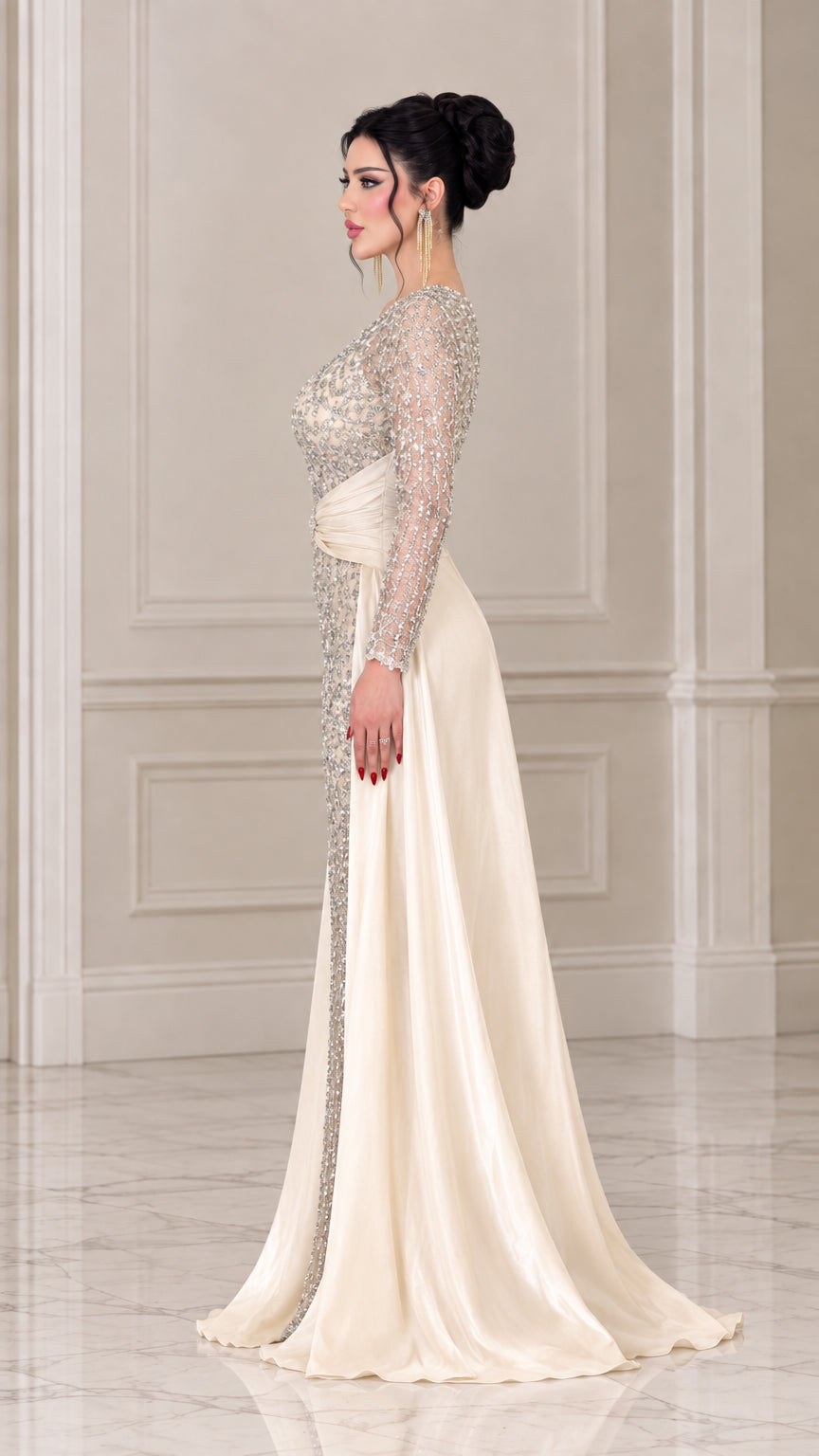 Side angle view of woman modeling the champagne embellished formal gown with dramatic train