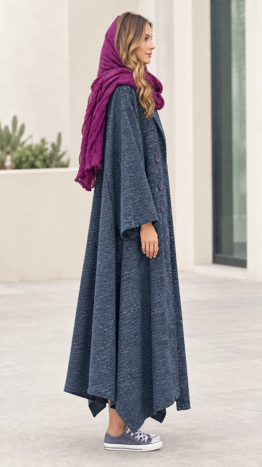 Side profile view of woman modeling Slate Blue asymmetric longline coat