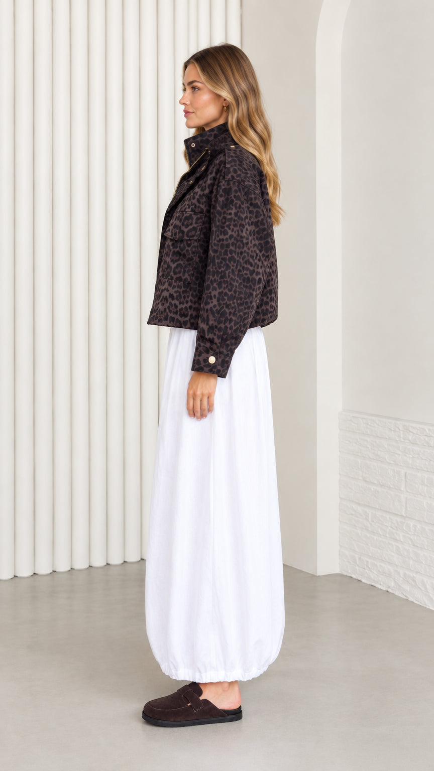 Side profile view of woman styled in dark brown leopard print cropped zip jacket