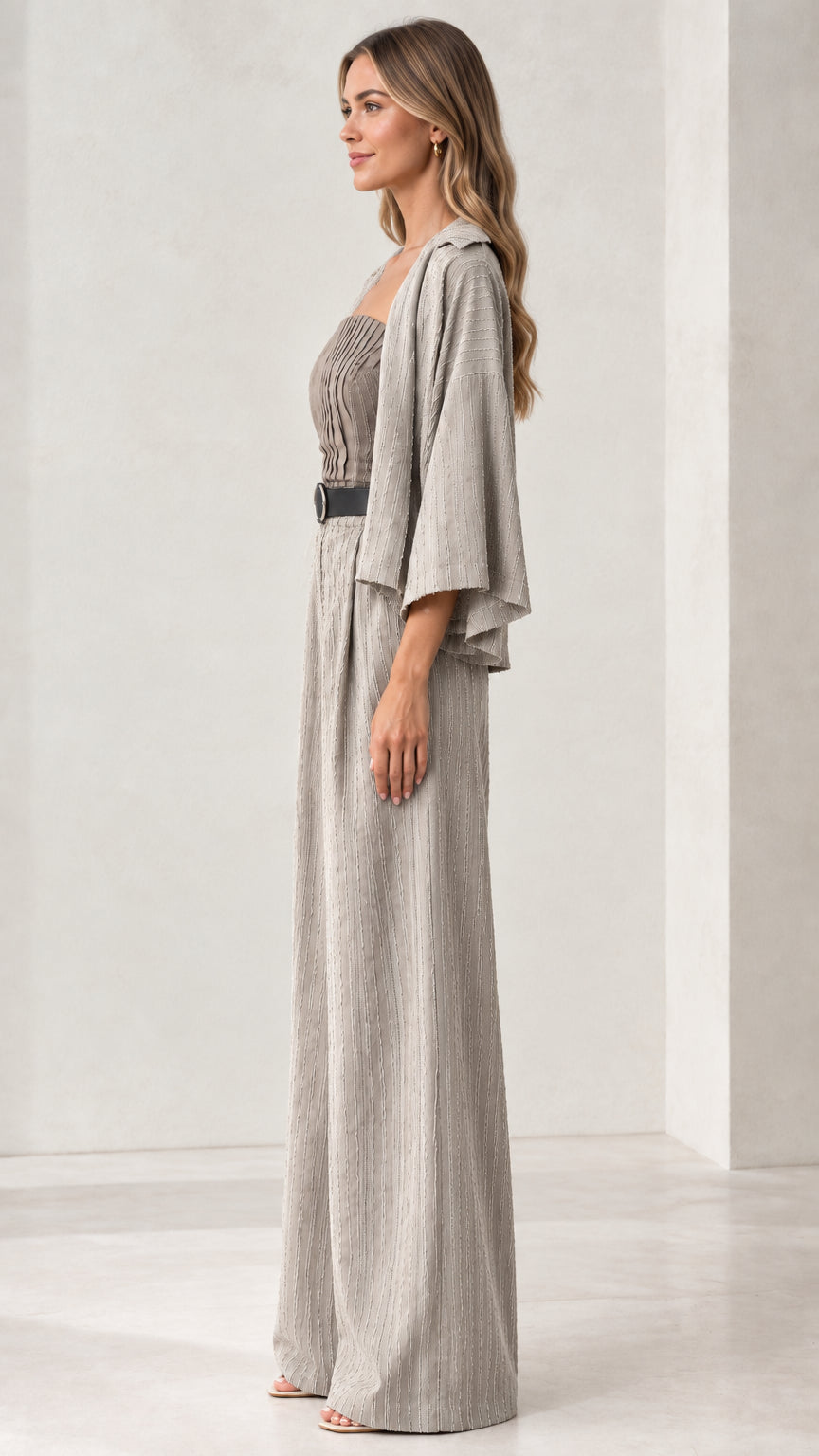 Side profile of woman wearing light grey pleated wide-leg jumpsuit set