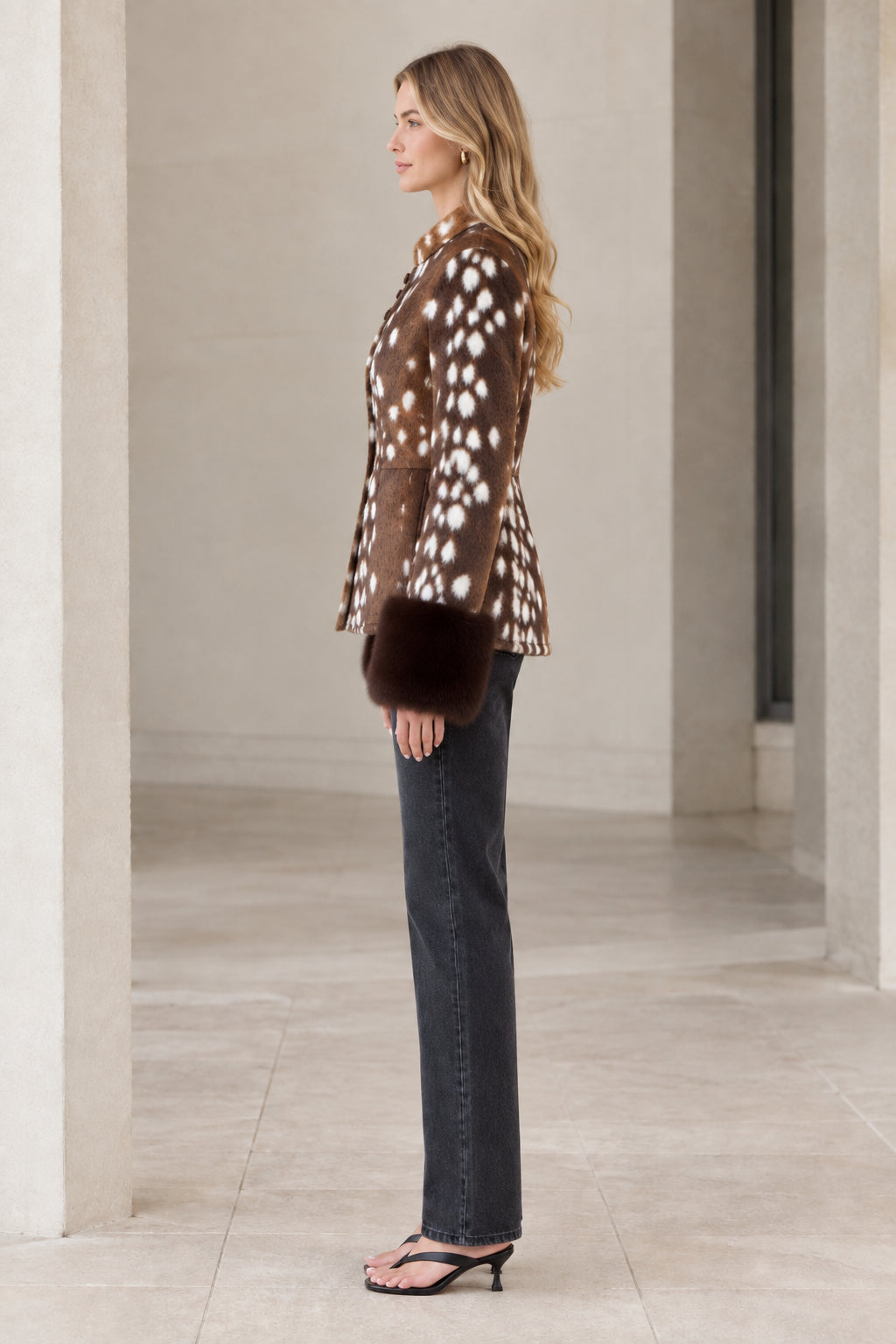 Side profile view of model wearing brown spotted faux fur button jacket