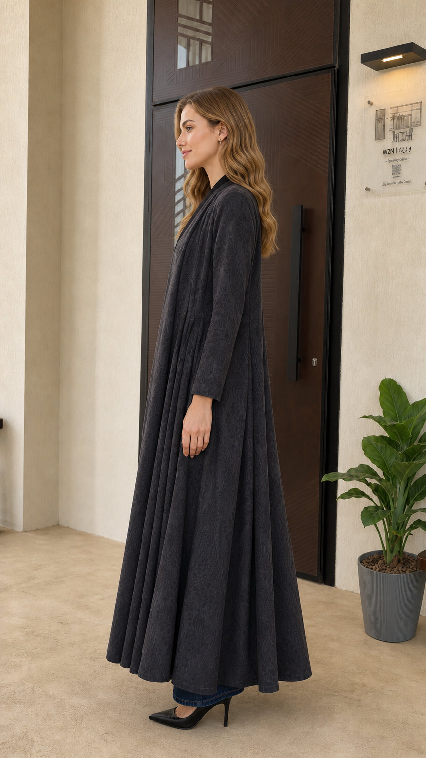 Side full-length view of woman wearing charcoal grey flowing open-front maxi coat