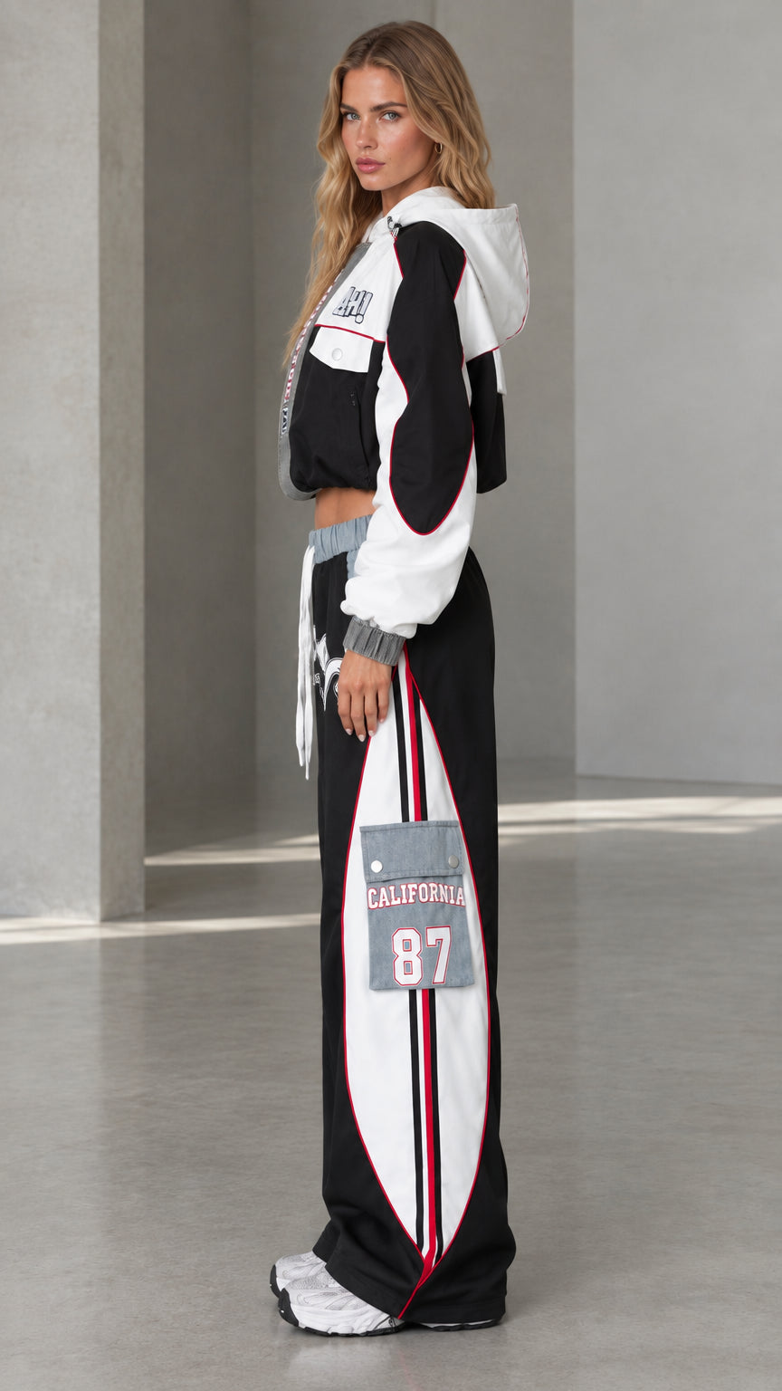 Side profile of model wearing black two-piece streetwear tracksuit set