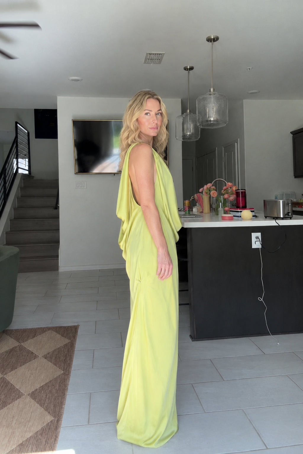 Side profile of woman in Lime Green cowl neck open back maxi dress