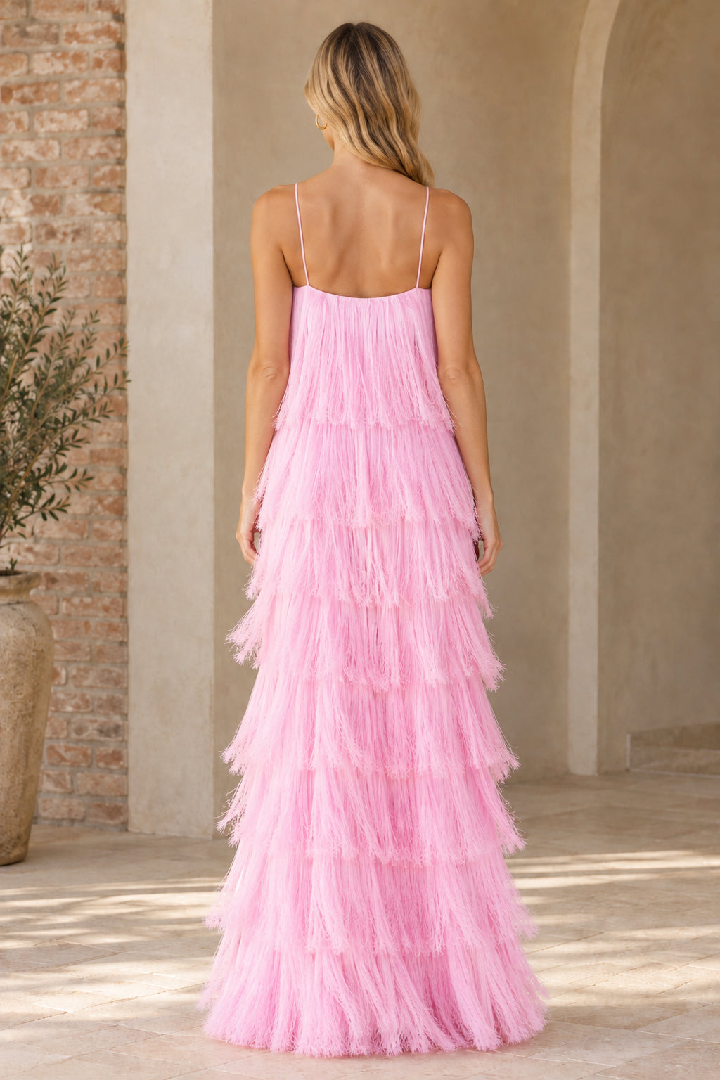 Back view of woman wearing pink tiered fringe sleeveless maxi dress