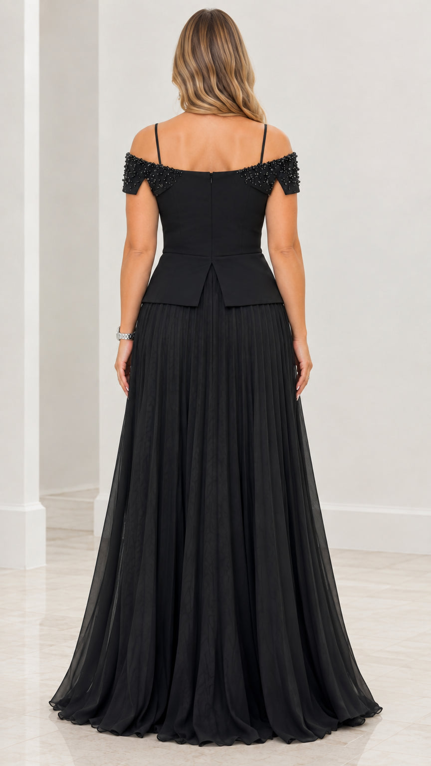 Back view of black cold-shoulder evening gown with pleated skirt