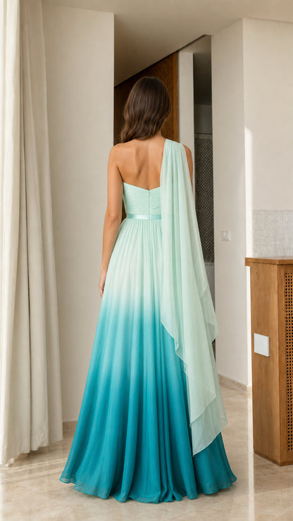 Back view of teal ombre floor-length gown highlighting the flowing cape sash
