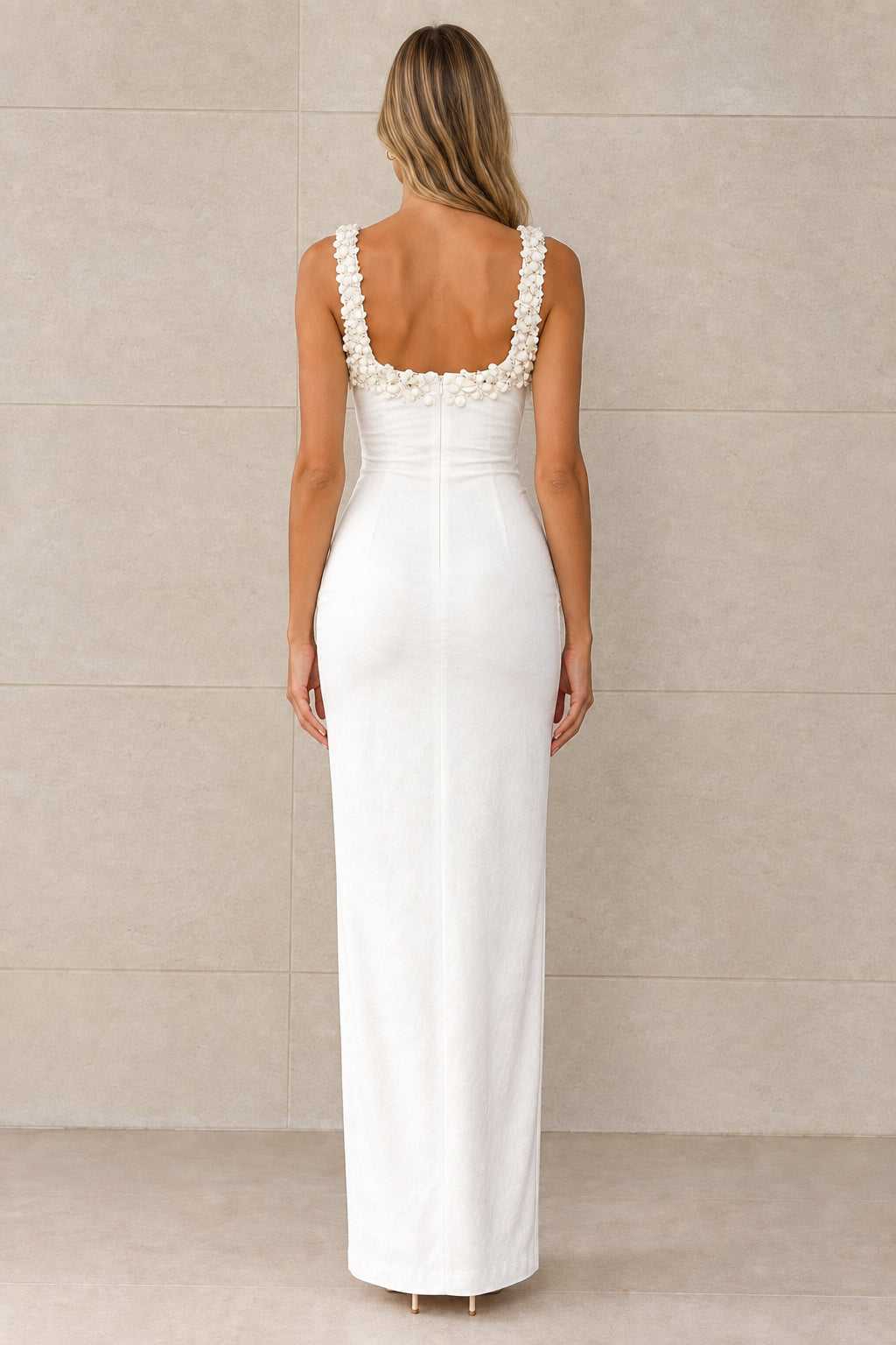 Back view of white sleeveless maxi dress showing scoop back and floral shoulder straps