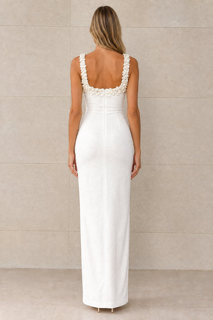 Back view of white sleeveless maxi dress showing scoop back and floral shoulder straps