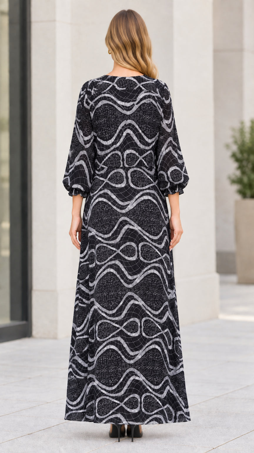 Back view of model wearing long sleeve black wave pattern maxi dress