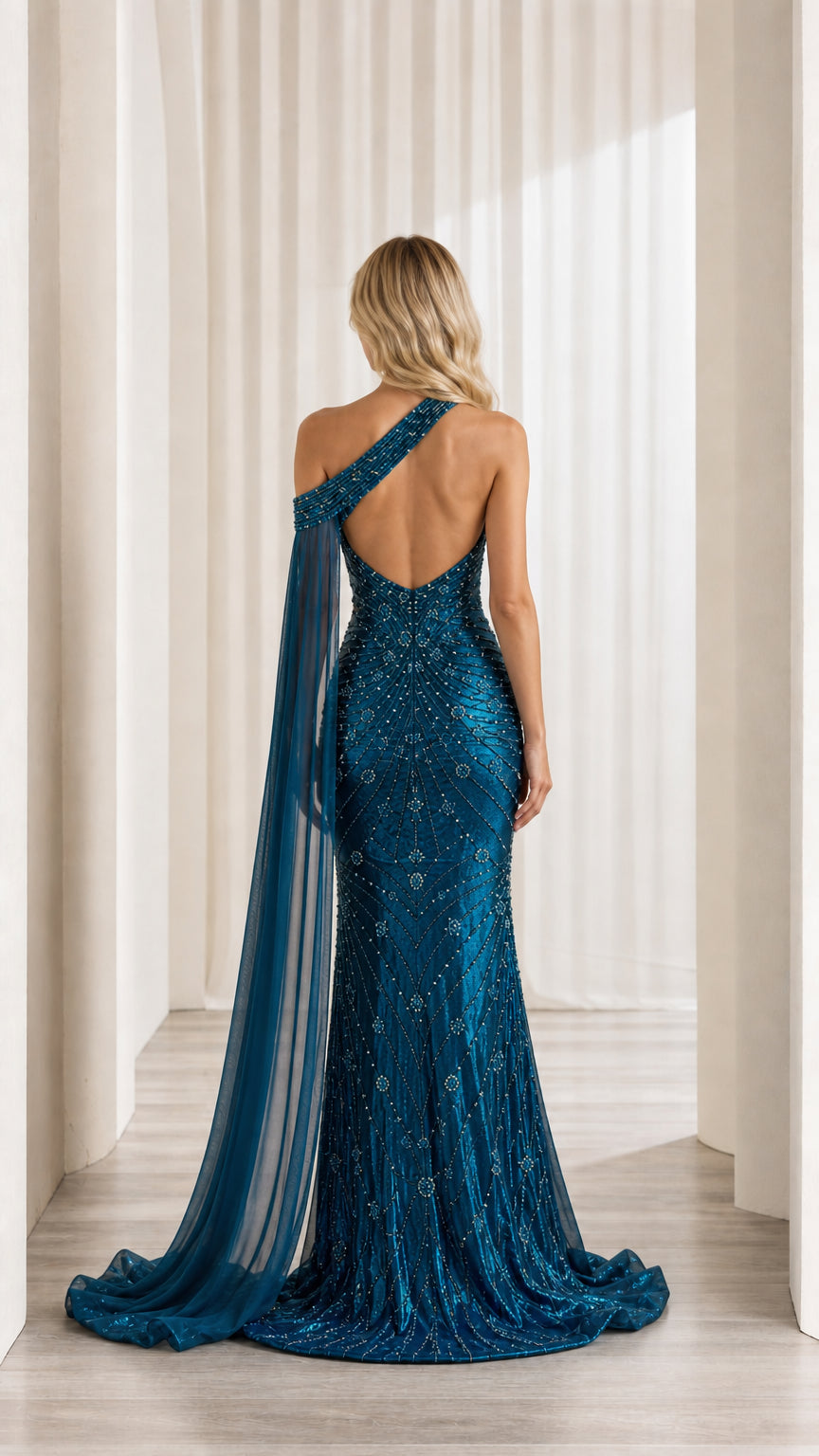 Back view of teal blue formal evening gown showing open back cutout and cape drape