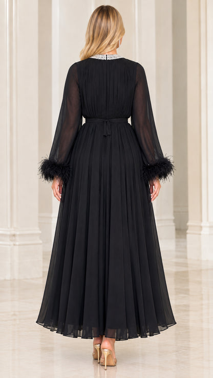 Back view of black pleated chiffon gown showing neat neckline and flowy skirt