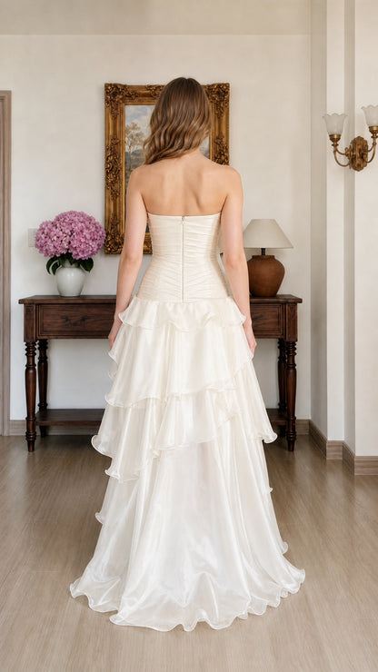 Back view of woman wearing Ivory strapless tiered ruffle evening gown