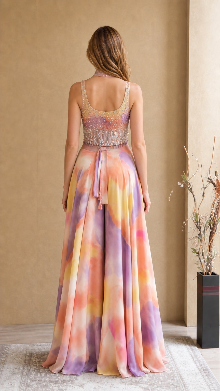 Back view of model showing open back and tie detail on tie-dye evening jumpsuit