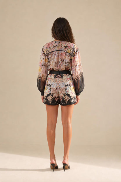 Back view of floral romper showing shorts length and overall fit