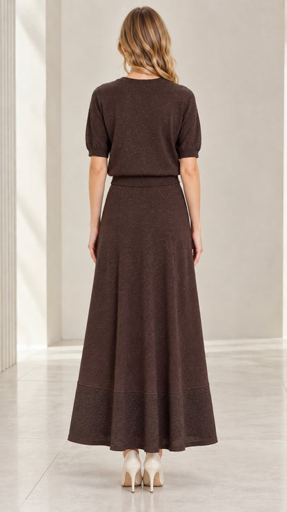 Back view of model in coffee brown short sleeve knit top and flowing maxi skirt