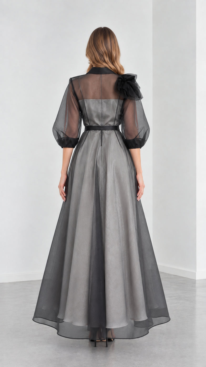 Back view of model showcasing the A-line drape and sheer upper back of Charcoal Grey gown