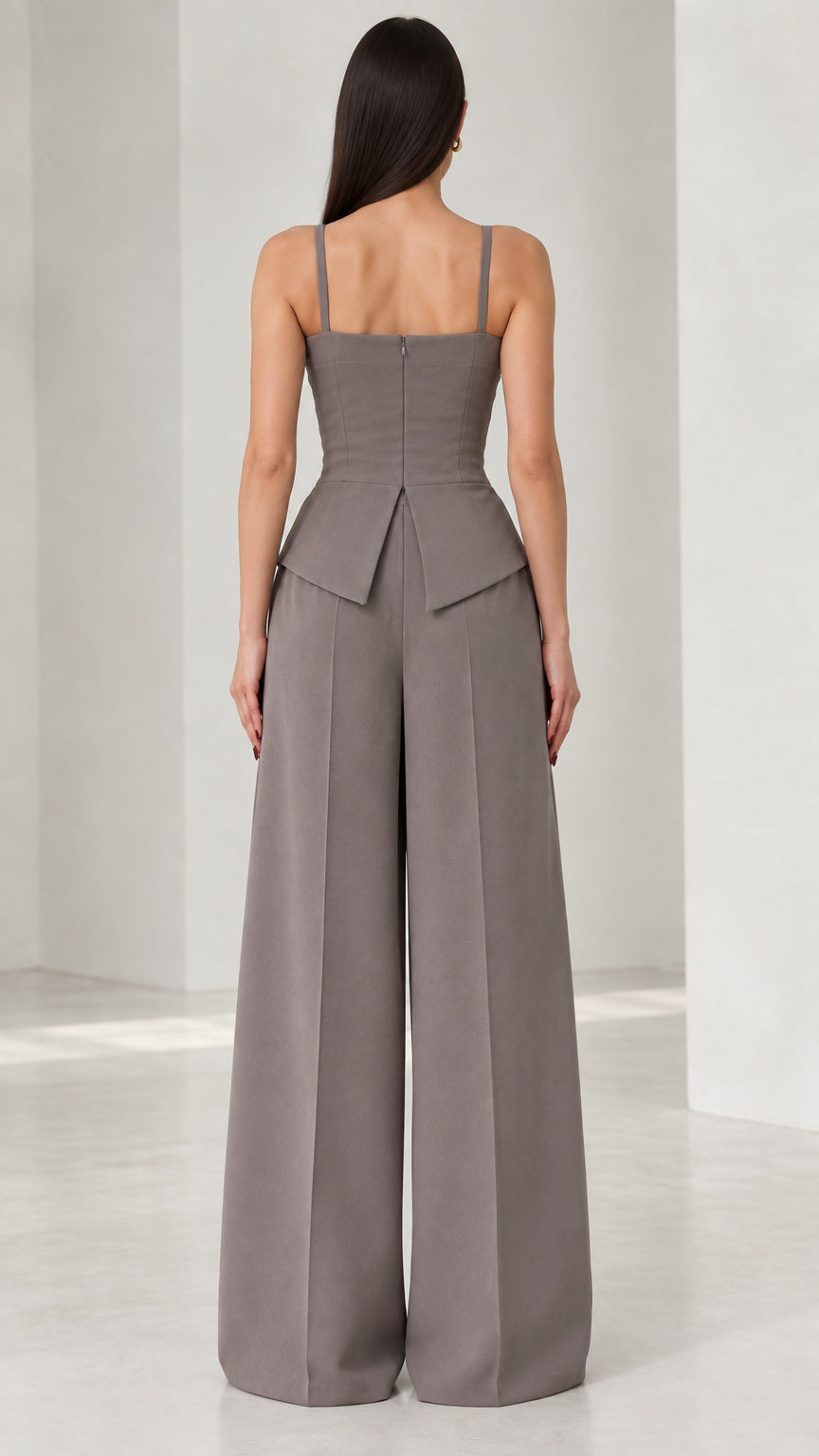 Back view of model wearing grey tailored wide leg jumpsuit with concealed zipper