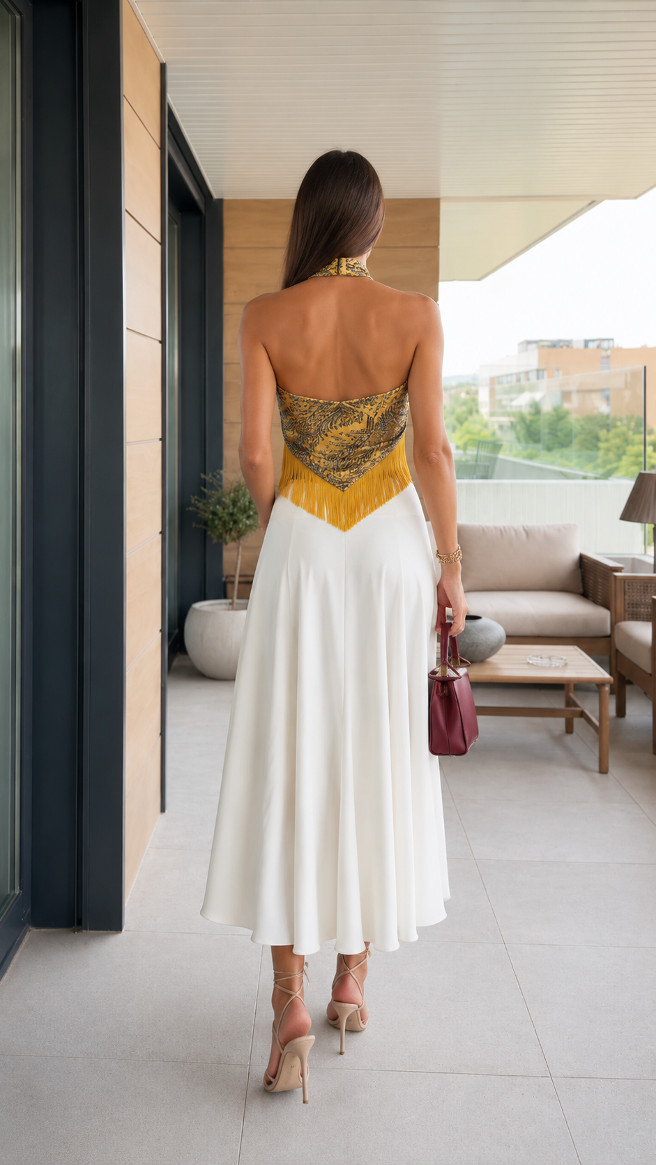 Gold open-back fringe halter top with white flowy skirt back view
