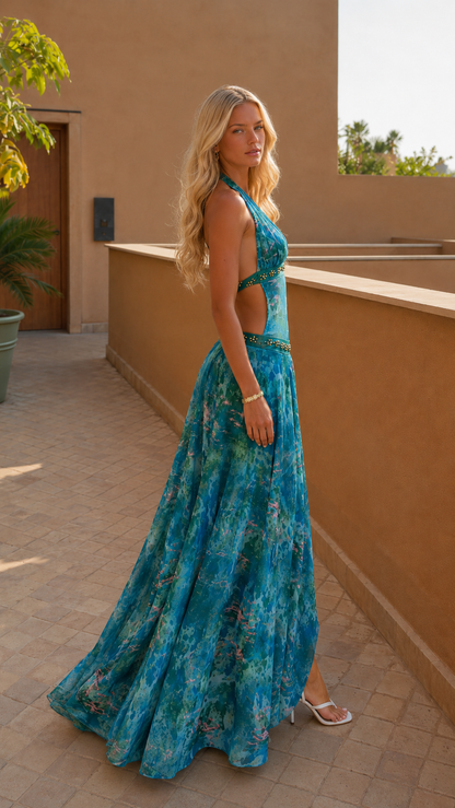 Side view of turquoise printed halter maxi dress with open back and sweeping skirt