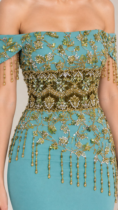 Close-up of intricate gold beading and fringe details on teal evening bodice