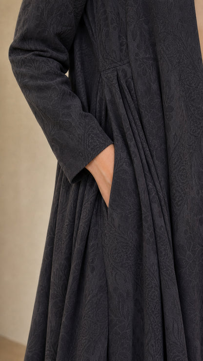 Close-up detail of charcoal grey jacquard textured fabric, side pocket, and waist pleats