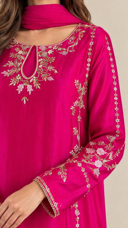 Close-up of intricate floral embroidery on fuchsia keyhole neckline and sleeve cuff