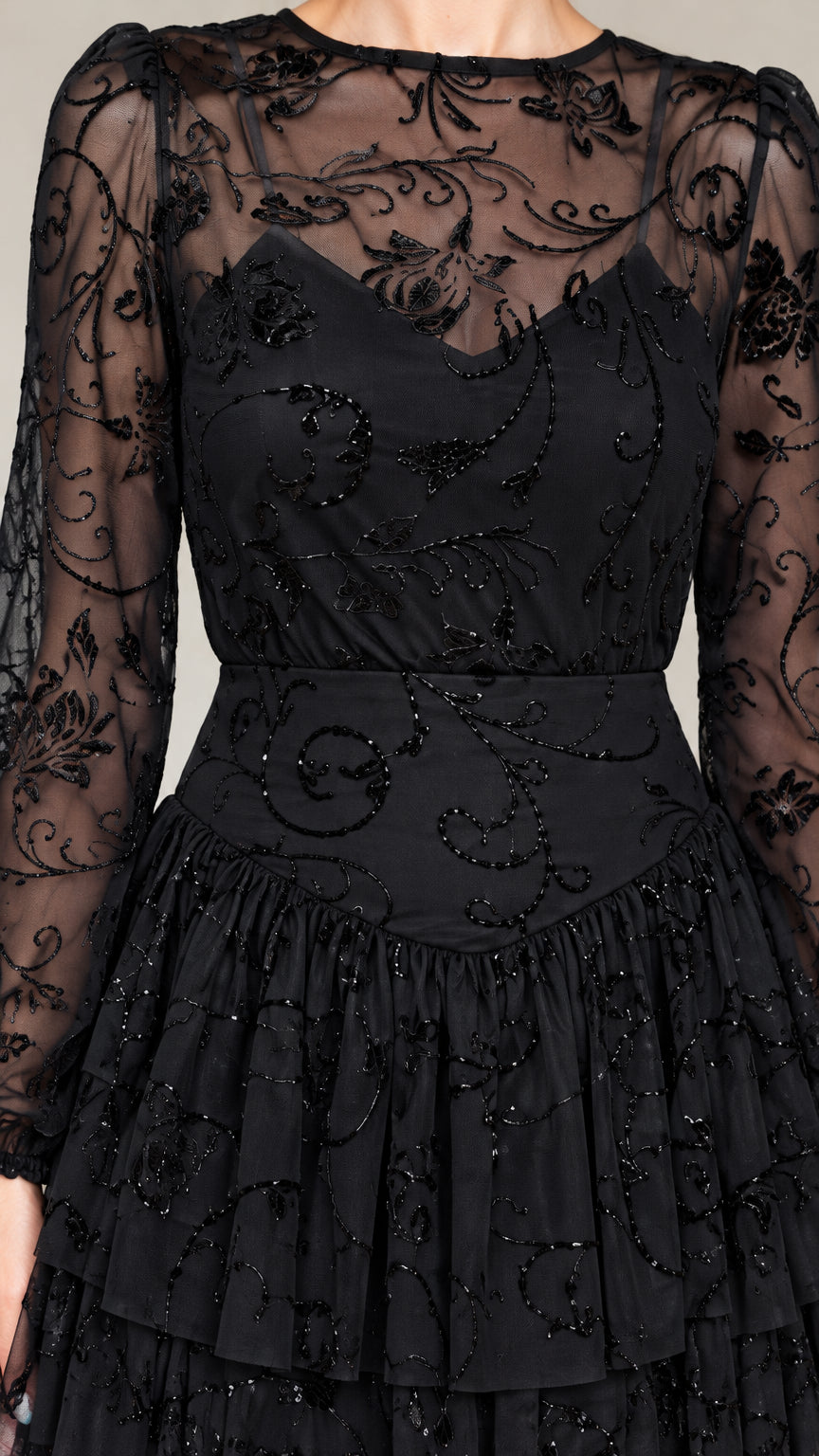 Close-up detail of Black illusion neckline with intricate beading and ruffle tiers