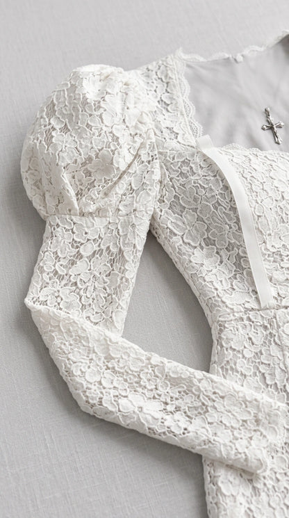 Close-up detail of white floral lace fabric and puff shoulder design