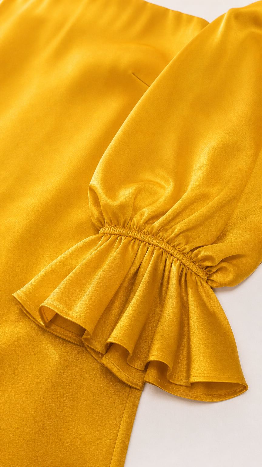 Close-up detail of gathered elastic ruffle cuff on yellow sleeve
