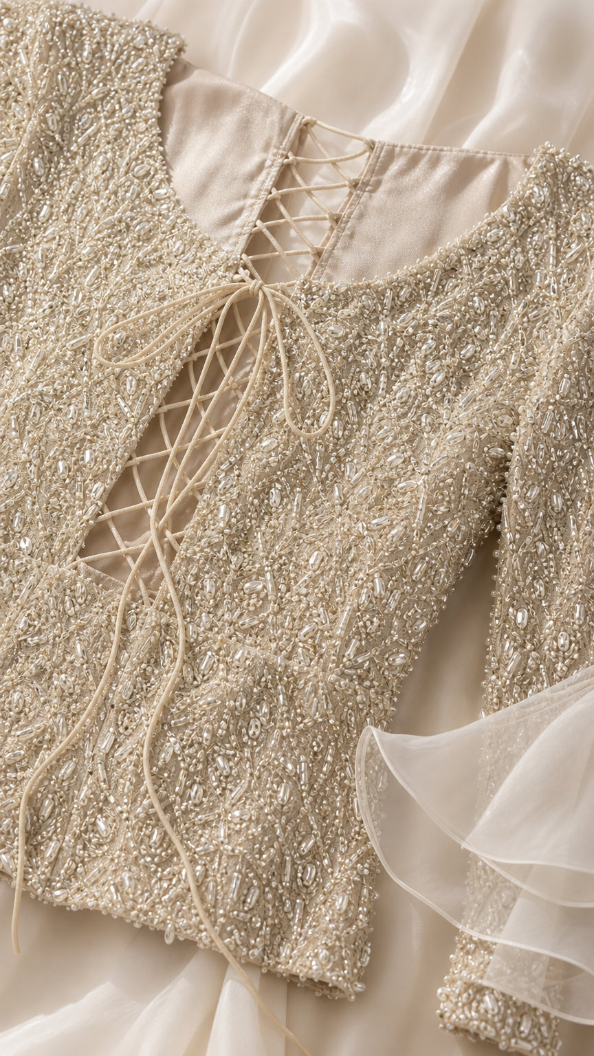 Close-up detail of intricate beadwork and lace-up back on Champagne evening dress