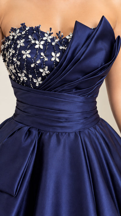 Close-up detail of navy blue bodice with floral crystal beadwork and origami pleated fold