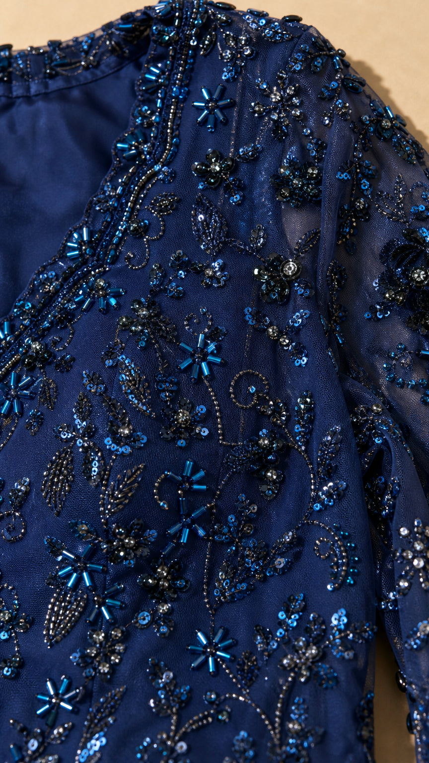 Detailed close up of intricate navy blue beadwork and floral sequin embroidery