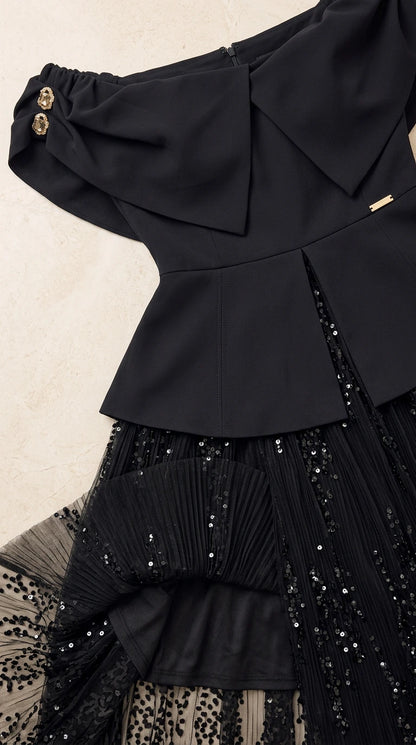 Close-up detail of structured bodice, foldover neckline, gold buttons, and sequin skirt