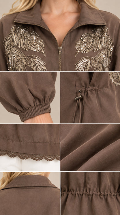 Close-up details of collar, sequin leaf embroidery, elastic cuff, drawstring toggle, and scalloped hem