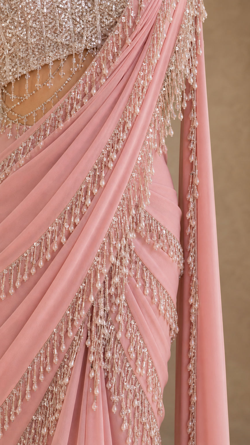 Close-up detail of beaded fringe trim and pleated chiffon drape on dusty pink gown