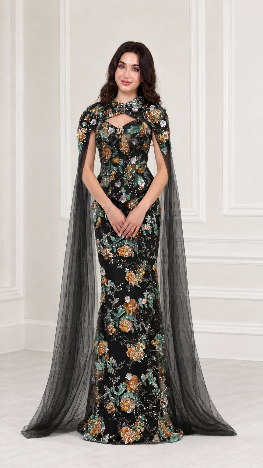 Front view of Black floral embroidered evening gown with sheer black cape