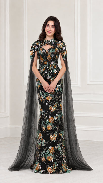 Front view of Black floral embroidered evening gown with sheer black cape
