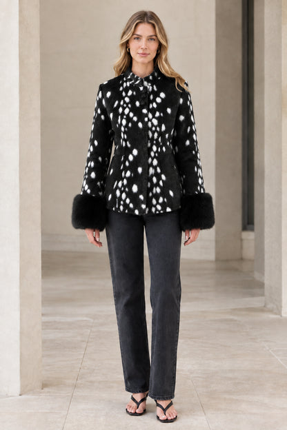 Front view of model wearing black spotted faux fur jacket with plush cuffs