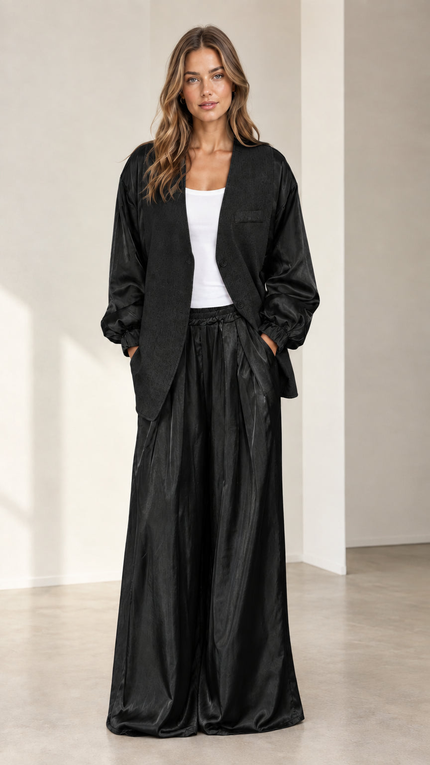 Front view of model wearing black satin sleeve jacket and wide-leg pants set