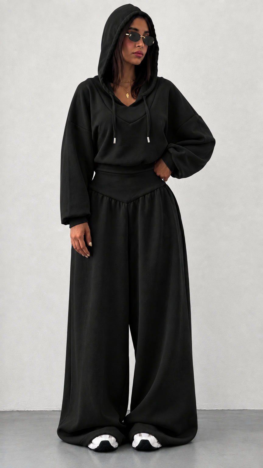 Woman wearing black 2-piece hooded sweatshirt and wide leg pants set